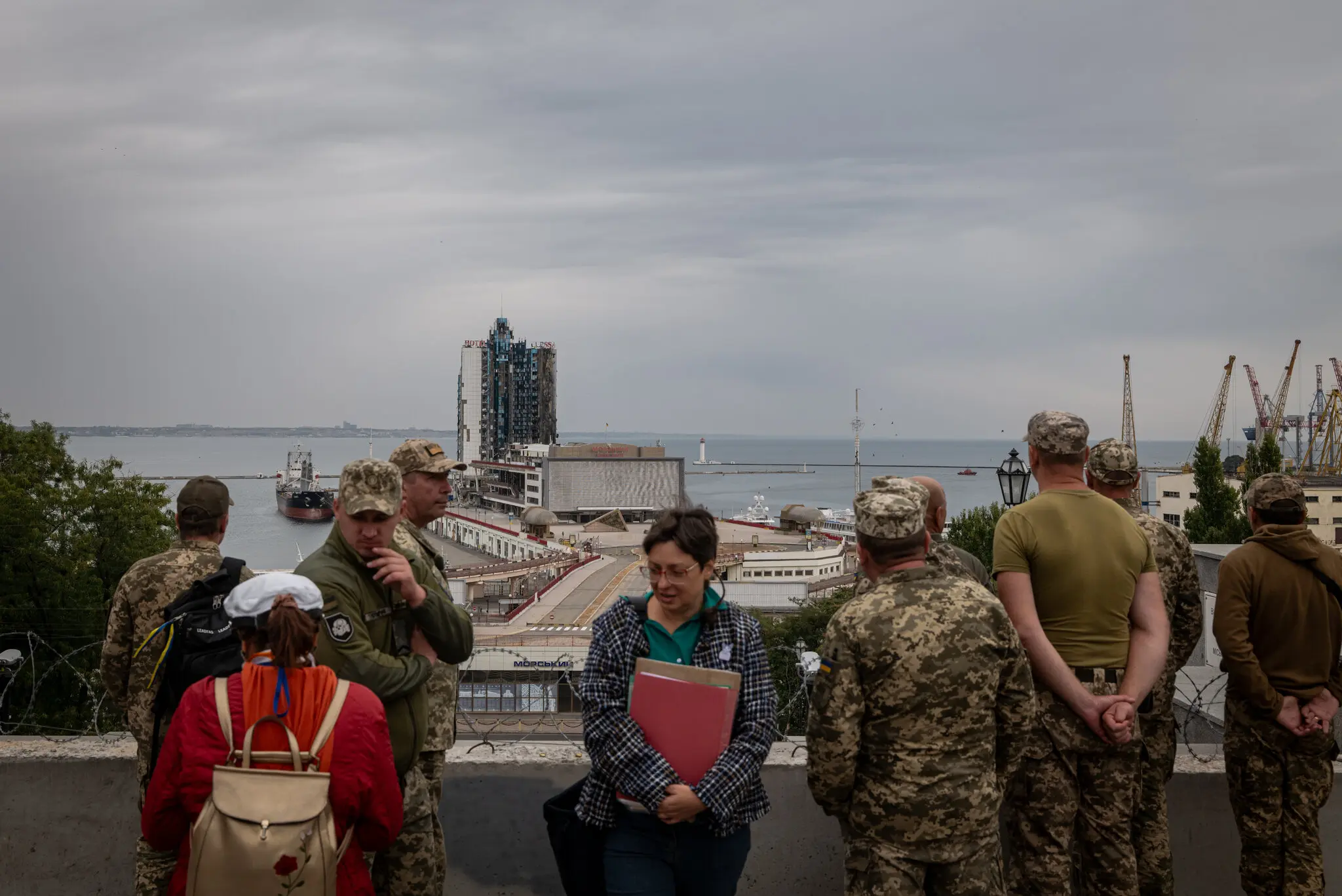 Українські військові з екскурсоводом (у центрі) в портовій зоні Одеси, обстріляній безпілотниками та ракетами, у вересні.